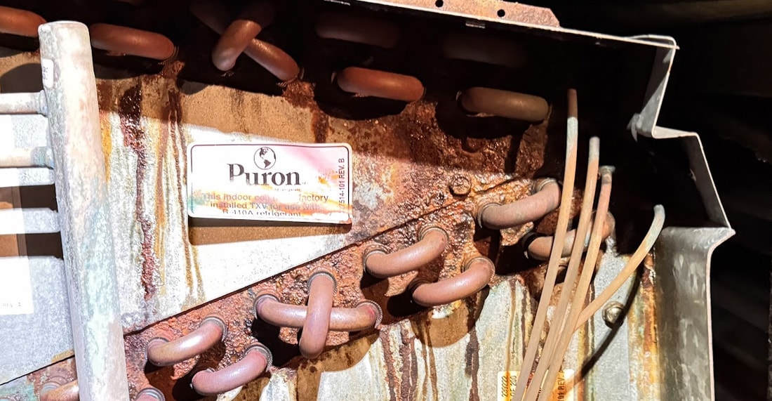 Advanced coil corrosion with active leaks visible