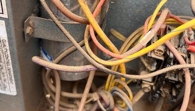 Dirty electrical compartment inside condenser with old capacitor and wiring